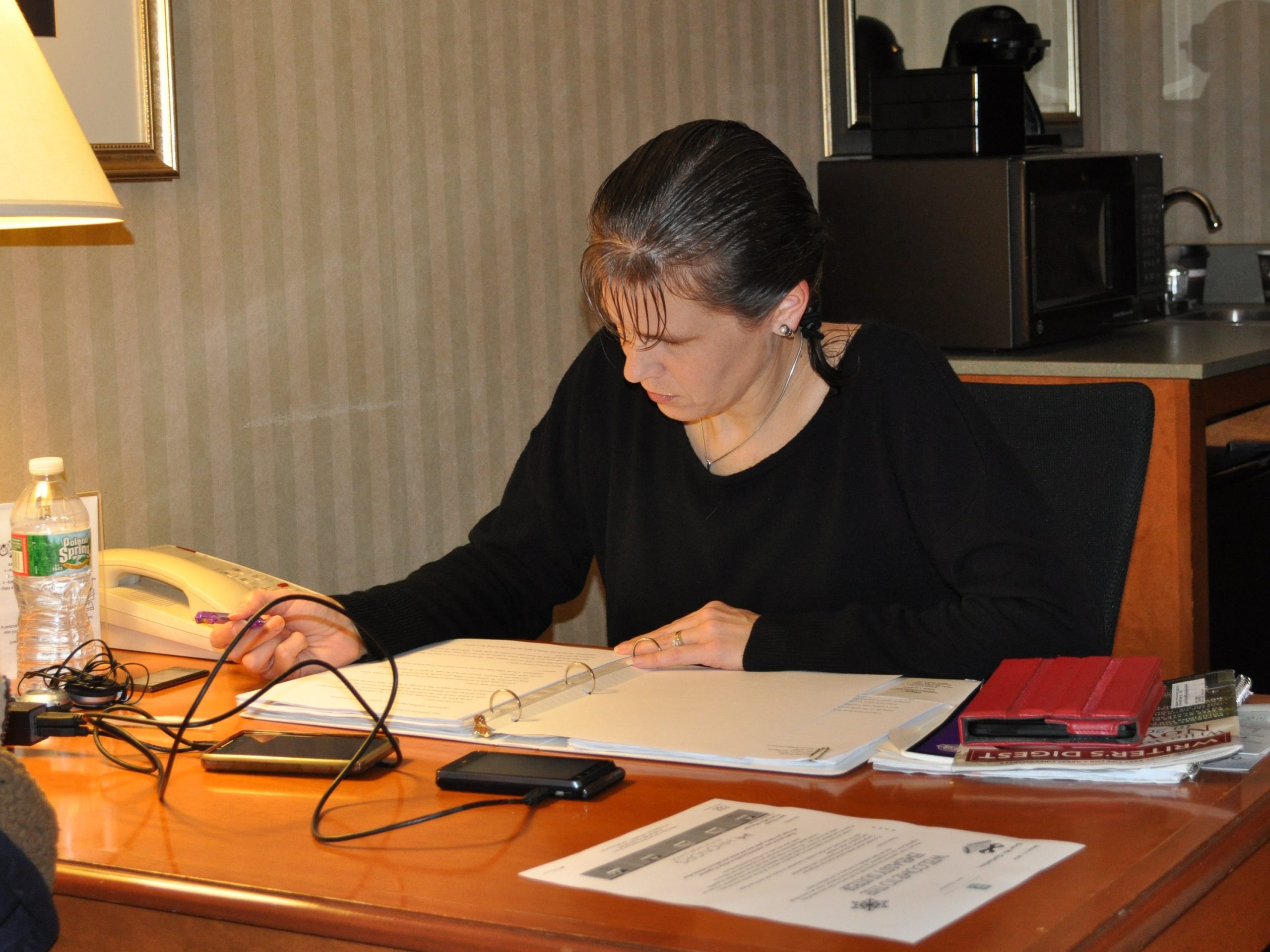 Woman sitting at a desk, writing.